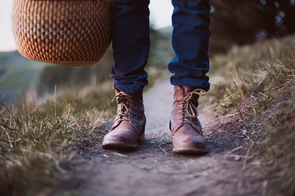 Boots and a gathering basket on a forest path
